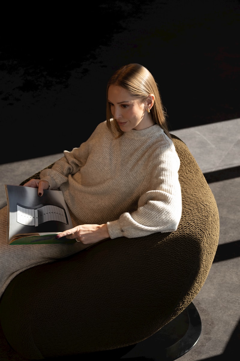 Woman reading a book in a modern armchair
