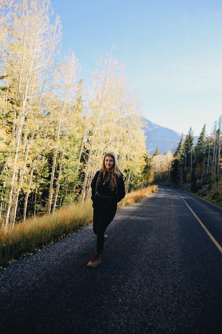 woman in black jacket standing on road during daytime